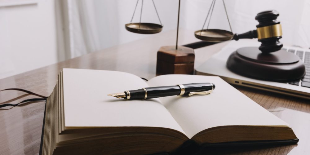Business and lawyers discussing contract papers with brass scale on desk in office. Law, legal services, advice, justice and law concept picture with film grain effect
